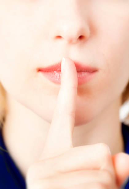 istock Young Woman with Finger in Front of Lips Gestruing Silence 466409413