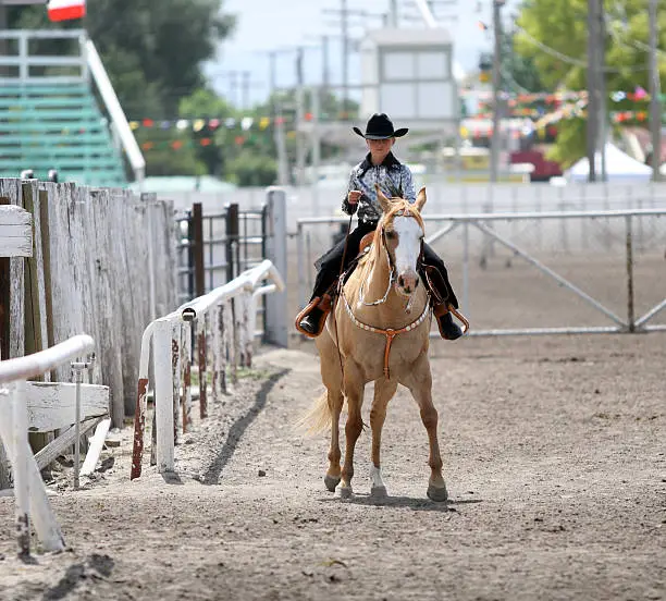 cowgirl contestant riding her horse in an arena during fair