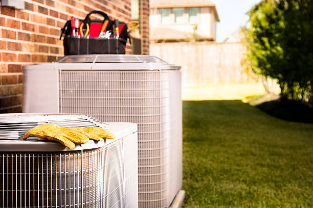 Service Industry:  Work tools on air conditioners. Outside residential home. Bag of repairman's work tools, gloves on top of air conditioner units outside a brick home.  Service industry, working class. air conditioner stock pictures, royalty-free photos & images