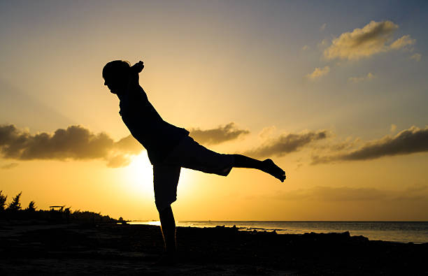 istock Silhouette of young man doing yoga at sunset 466414740