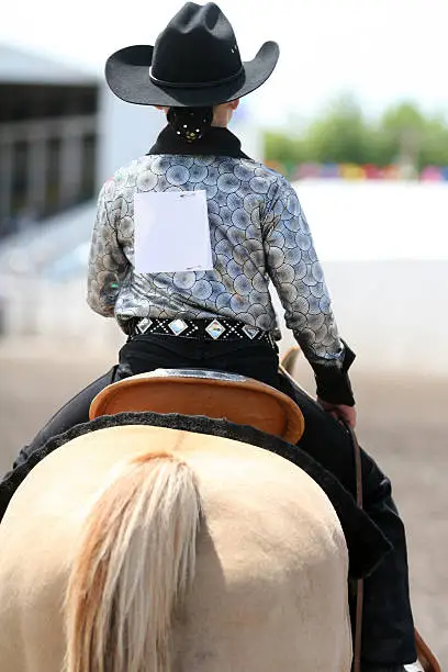 cowgirl contestant riding her horse in an arena during fair