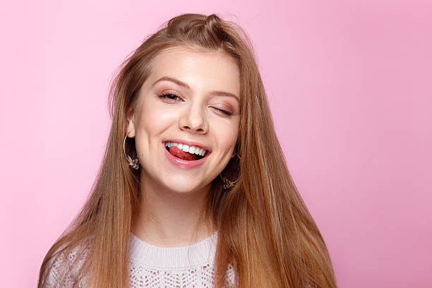 istock Pretty young woman smiling against a pink background. 466418164