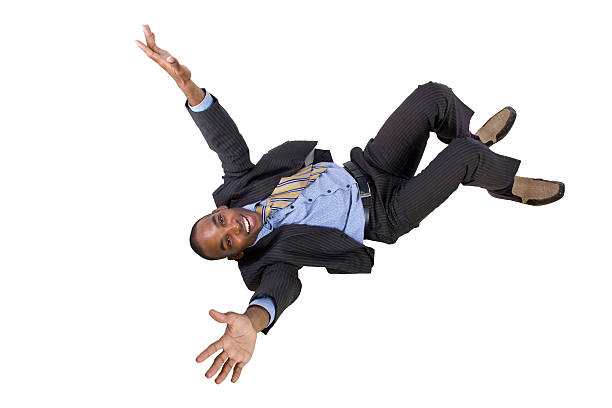 jovem empresário preto, caindo para trás - skydiving parachute parachuting taking the plunge - fotografias e filmes do acervo