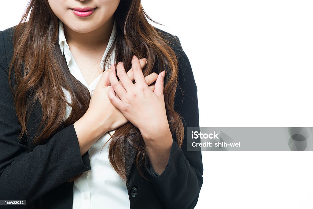 Business woman feeling heart pain and holding her chest 2015 Stock Photo