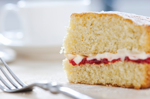 An individual slice of freshly baked Victoria Sponge cake with a fork, part of making a cake series