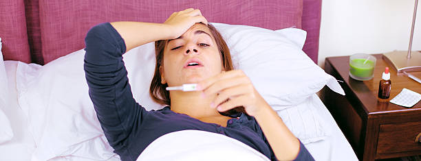 istock Super sick woman in bed checking temperature retro style 466423836
