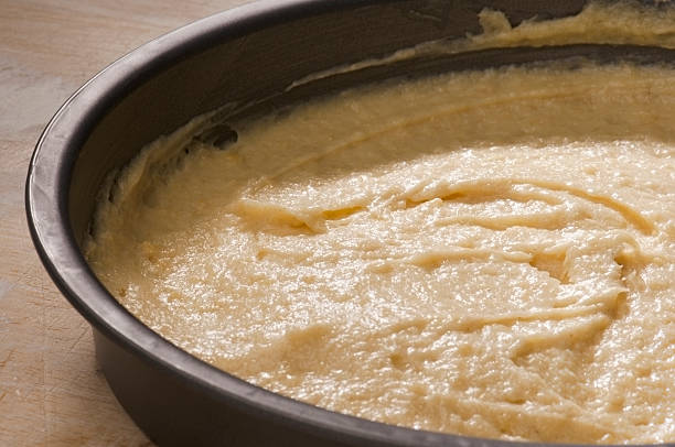 istock Uncooked cake mixture in a round oven tin 466424274