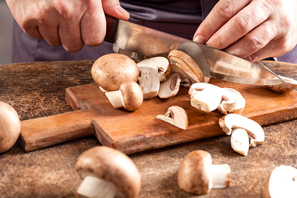 istock Chef cutting mushrooms on wooden cutting board 466424524