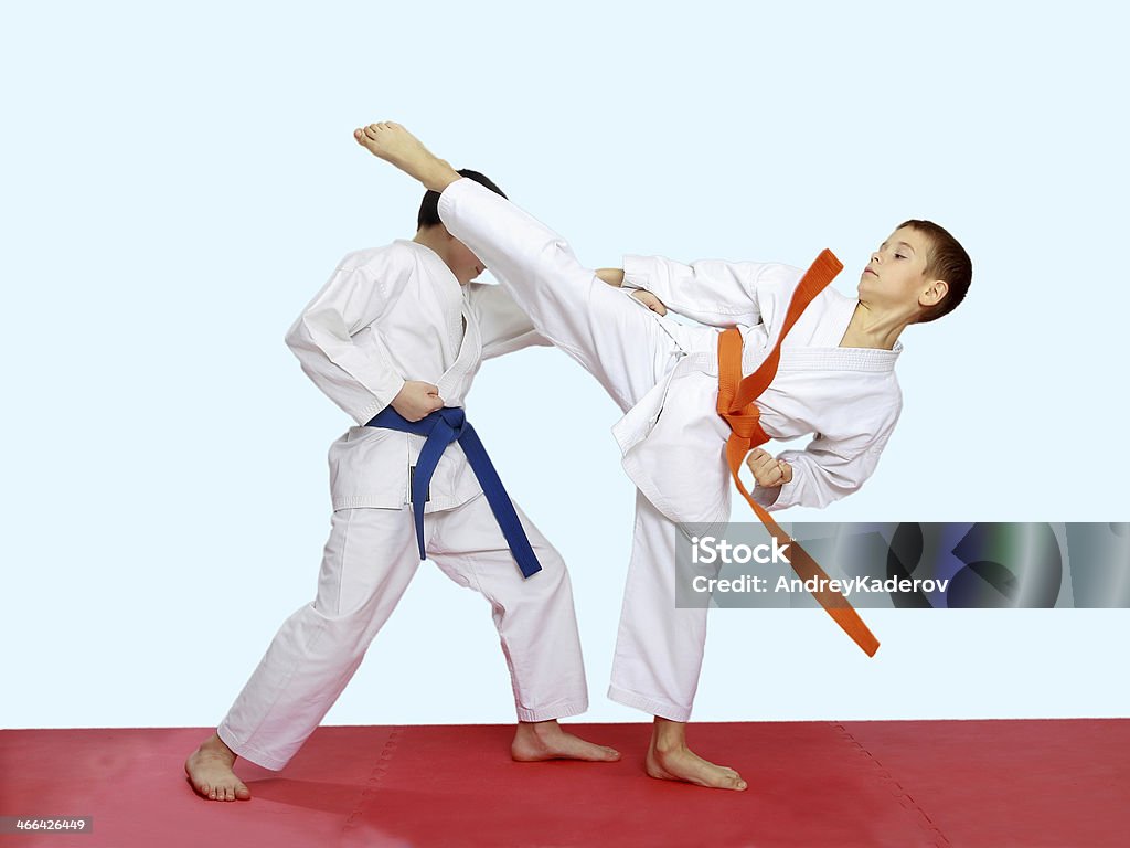 Blows karate are training athletes on a bright background Blows karate are training athletes on a bright and red background Activity Stock Photo