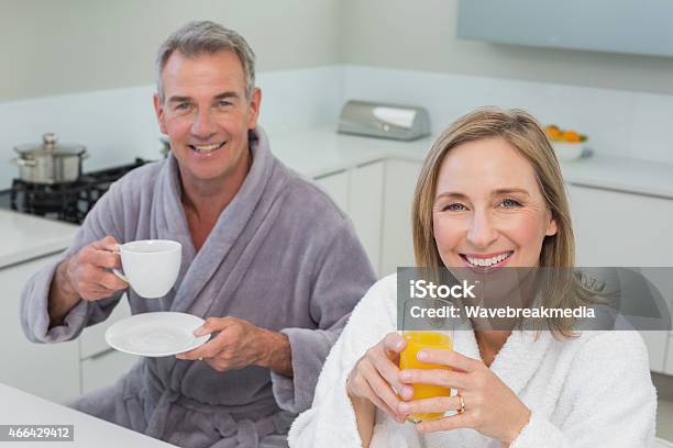 Smiling Couple With Orange Juice And Coffee In Kitchen Stock Photo - Download Image Now