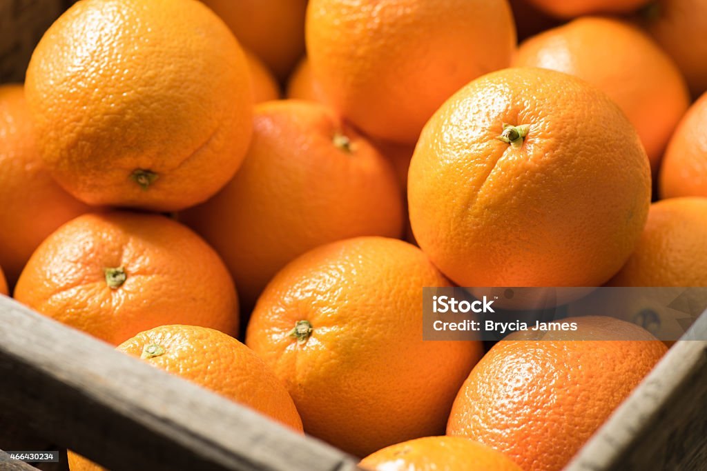 Navel Oranges in a Wooden Crate Navel Oranges in a wooden crate on a  black surface. Orange - Fruit Stock Photo