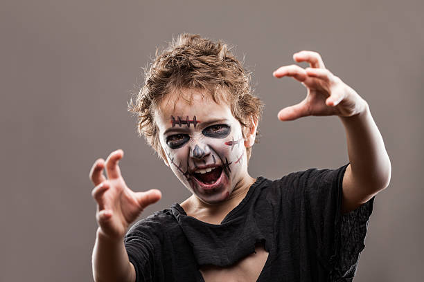 Screaming walking dead zombie child boy Halloween horror costume and makeup concept - screaming walking dead zombie child boy reaching hand face paint halloween adult men stock pictures, royalty-free photos & images