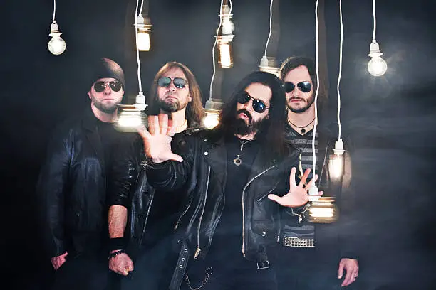 A promo photo for a four piece heavy metal band. Intentional montion blur on light bulbs and hands.