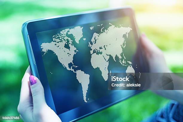 Hands Holding Digital Tablet Displaying World Map Stock Photo - Download Image Now - 2015, Adult, Cartography