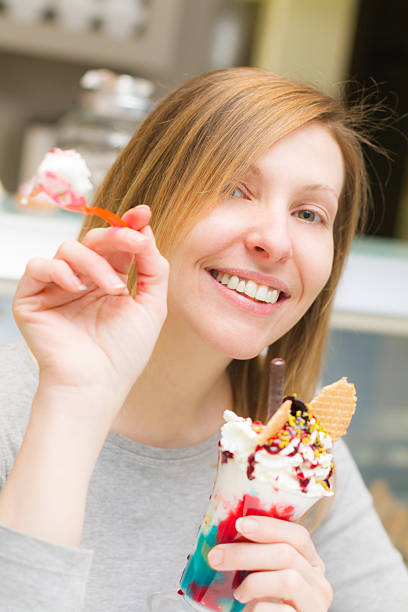 mujer joven deliciosa taza de café con cuchara de helado - spoon tasting women sex symbol fotografías e imágenes de stock