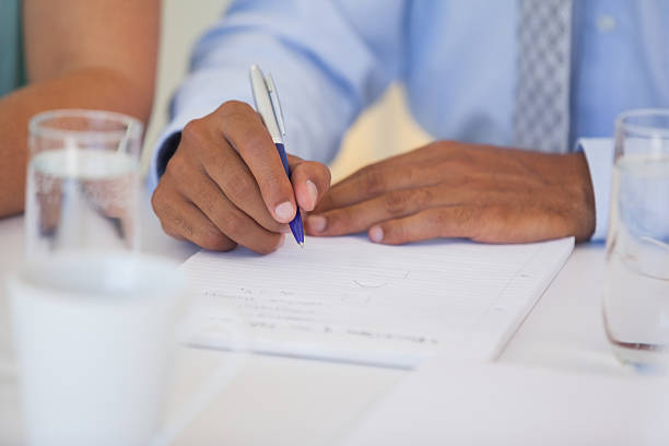 istock Close-up mid section of a businessman writing document 466438746