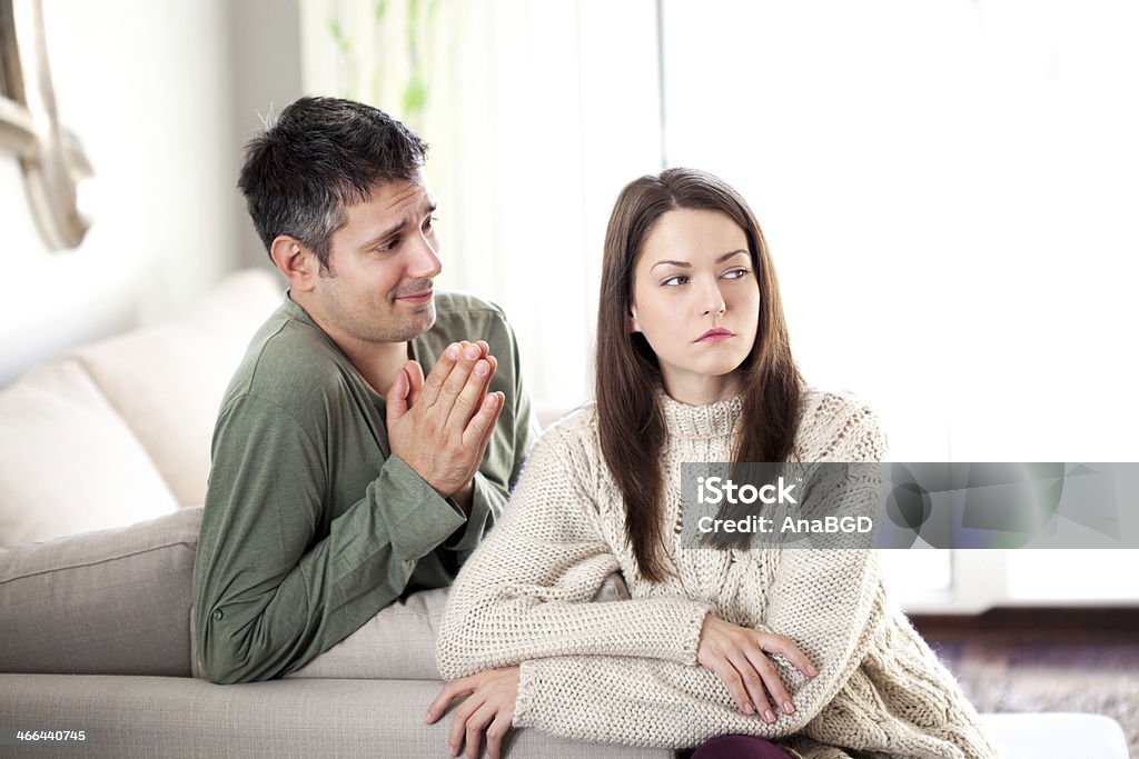 Begging her Image of young man begging his girlfriend to forgive him Begging - Social Issue Stock Photo