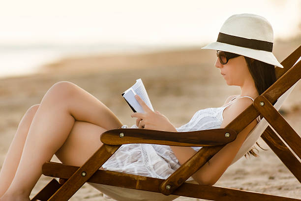 istock Beautiful Woman Reading on Beach Chair 466441956