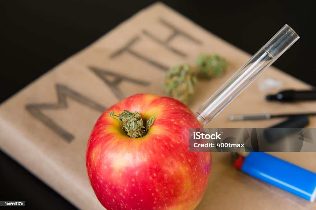 Marijuana in School An apple bong and marijuana on a math book. Bong Stock Photo