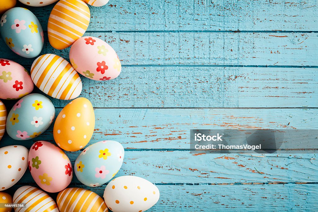 Easter Eggs on Old Blue Wood - Season Background Frame Close up photography of decorative multi colored easter eggs lying on vintage blue wood. Great for design for easter and spring related subject area. Photo captured with a Zeiss Makro-Planar T* 2/50mm at f8.  Easter Stock Photo
