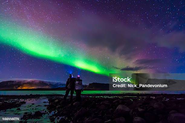 Young Couple Hugged Under Northern Lights Aurora Borealis In Iceland Stock Photo - Download Image Now