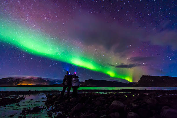молодая пара hugged под northern lights северное сияние в исландии - landscape iceland mountain green стоковые фото и изображения