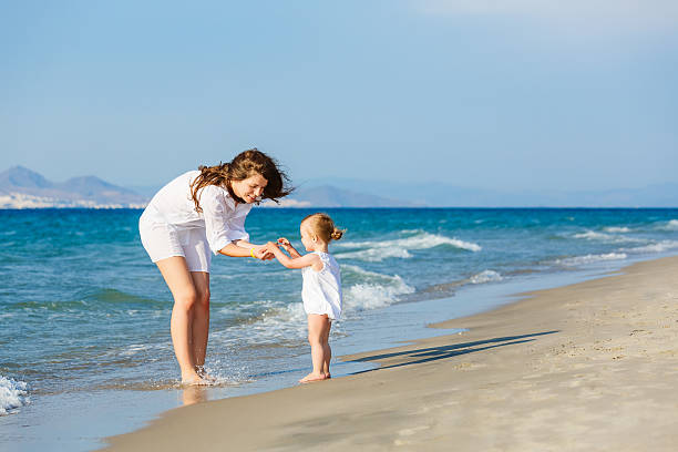 istock Mother and daughter playing on the beach 466447036