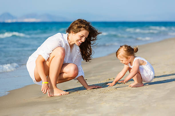 istock Mother and daughter playing on the beach 466447042