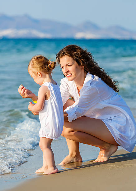 istock Mother and daughter playing on the beach 466447044
