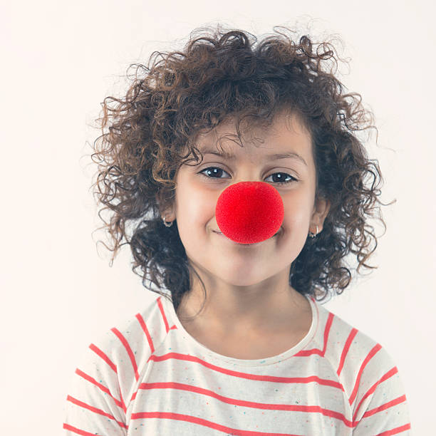 Happy clown Little girl with a big clown nose clowns nose stock pictures, royalty-free photos & images