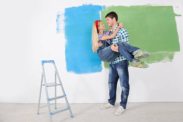 istock happy couple paint wall at new home 466452359