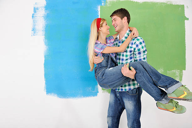 istock happy couple paint wall at new home 466452427