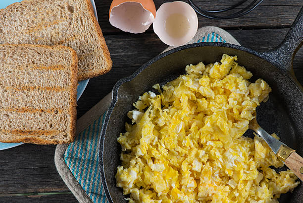 istock scrambled eggs in vintage frying iron pan, overhead view 466453322