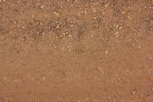 istock Texture of dry red clay with stones close-up. 466454558