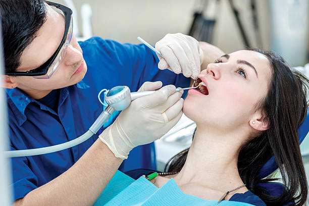 istock Dentist working on teeth. Smiling female patient sitting in the 466454640