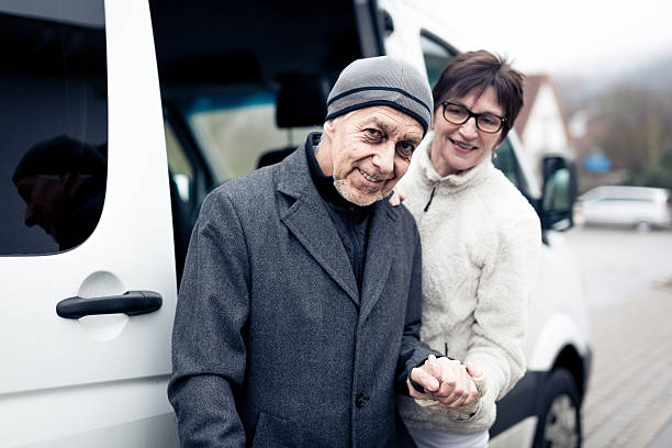 istock nurse helping senior man enter a van 466457329