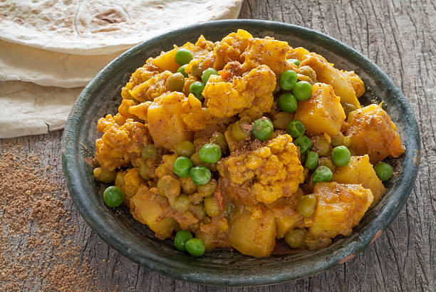 couve-flor e batata curry com verde ervilhas acompanhados de chapattis. - tomato curry imagens e fotografias de stock