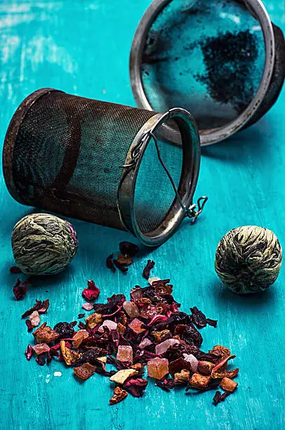 the leaves of the tea brewing on turquoise wooden background