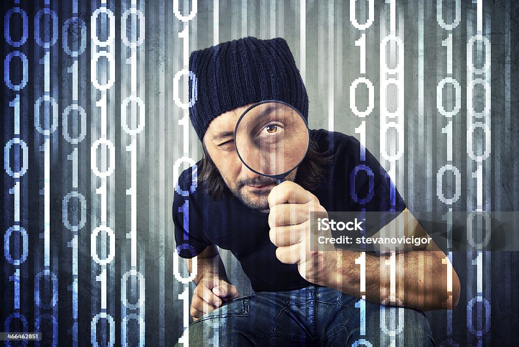 Man looking through magnifying glass Man looking through magnifying glass and inspecting binary code Adult Stock Photo