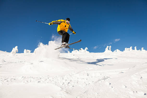 Man Snow Skiing making a jump stock photo