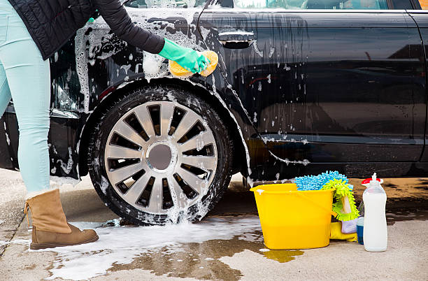 Car Wash Female worker at car wash service washing a car. bucket and sponge stock pictures, royalty-free photos & images