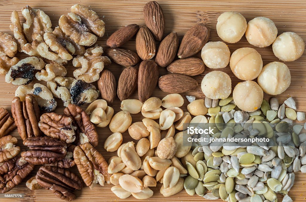 nuts and seets Variety of nuts and seeds on cutting board 2015 Stock Photo