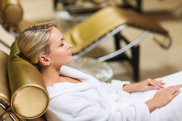 istock beautiful young woman sitting in bath robe at spa 466472304