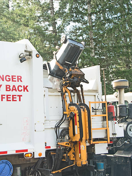 istock Garbage truck picking-up residential garbage bins 466472616