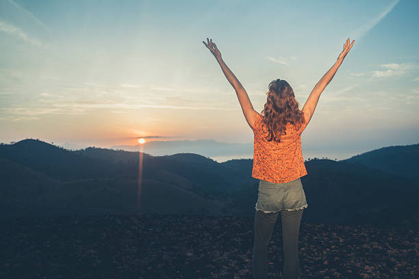 istock Woman watching sunrise over mountains 466478170