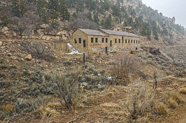 Large Abandoned Stone Building Large, stone building on a hill in a Utah ghost town on a snowy, winter day. carbon county utah stock pictures, royalty-free photos & images