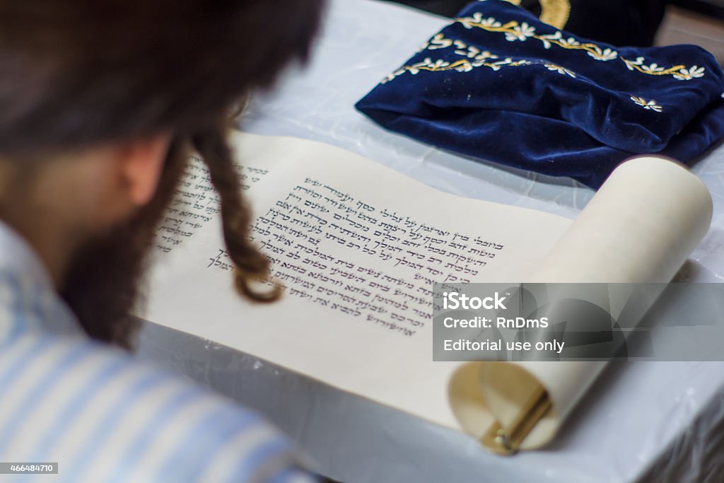 Purim in Jerusalem Jerusalem, Israel - March 5, 2015: An ultra-orthodox Jew reads the book of Esther (the megillah), as part of the traditions of the holiday of Purim, in Jerusalem, Israel Book Stock Photo