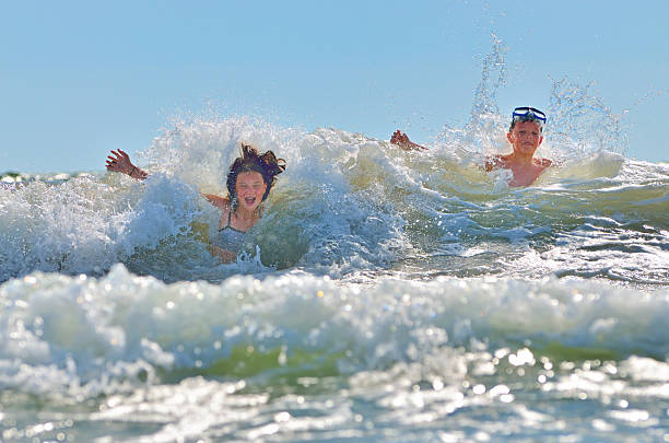 istock happy kids playing on beach 466489581
