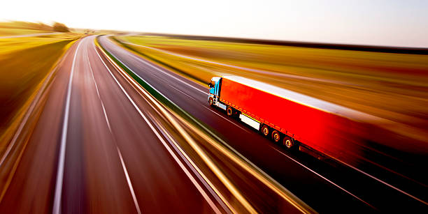 lkw auf der asphaltierten straße motion blur - red shipping freight transportation cargo container stock-fotos und bilder