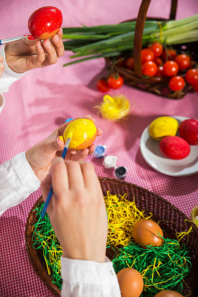 istock Close up of mother with daughter coloring eggs for Easter. 466491296